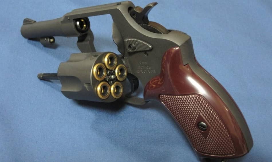 Closeup picture of a revolver with open cylinder.