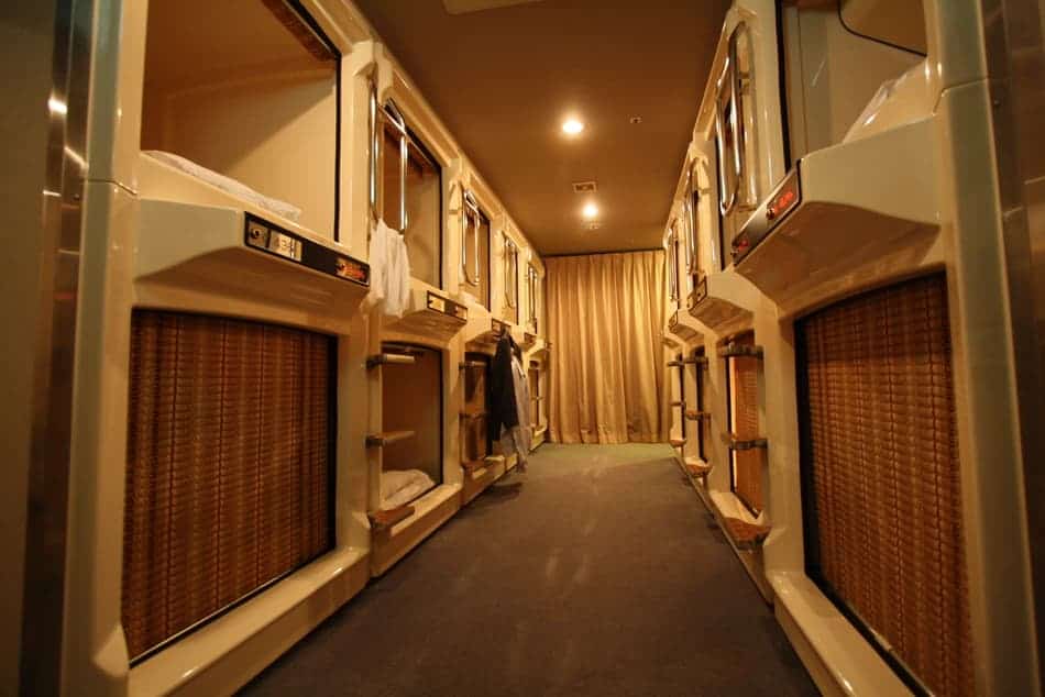 A photo inside a capsule hotel with pods on both sides