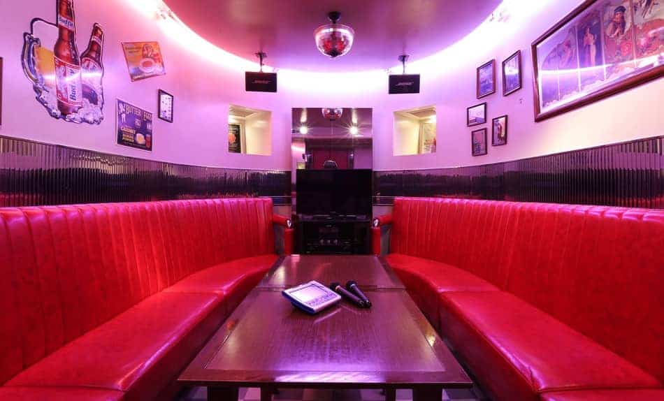A karaoke room with red sofas