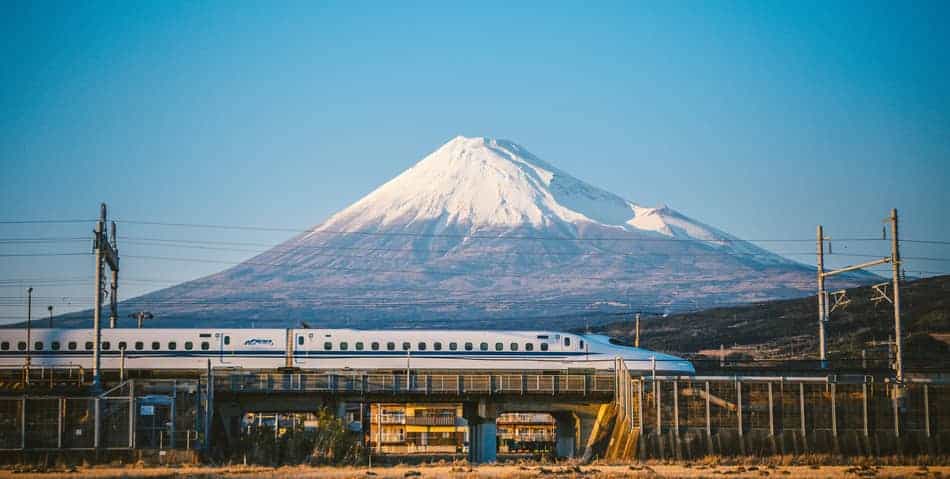 Shinkansen on a sunny day in front of Mount Fuji
